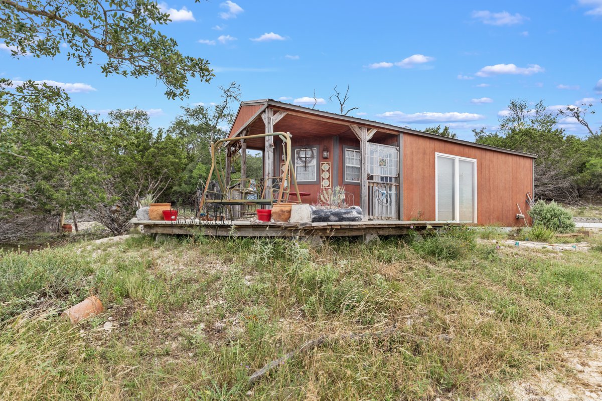 Artesia Hilltop Cabin — small red cabin with porch swing