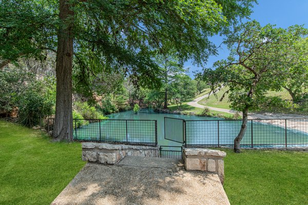 Fenced spring-fed swimming pond on the property